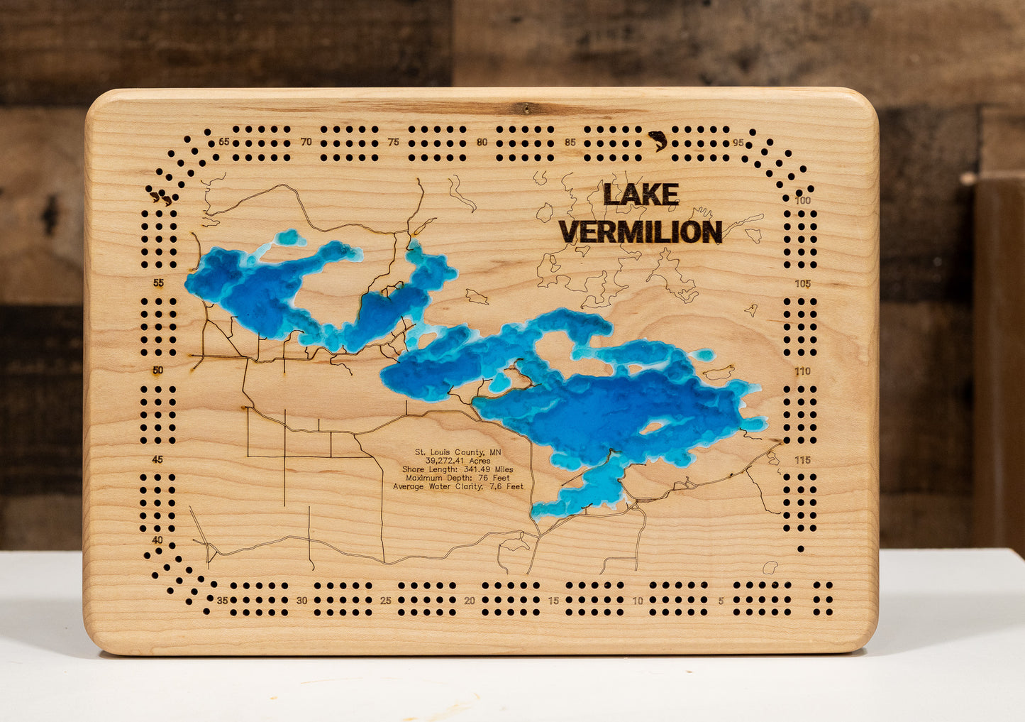 oak Cribbage board with Lake Minnetonka 3d carved into it and then filled in with blue epoxy.