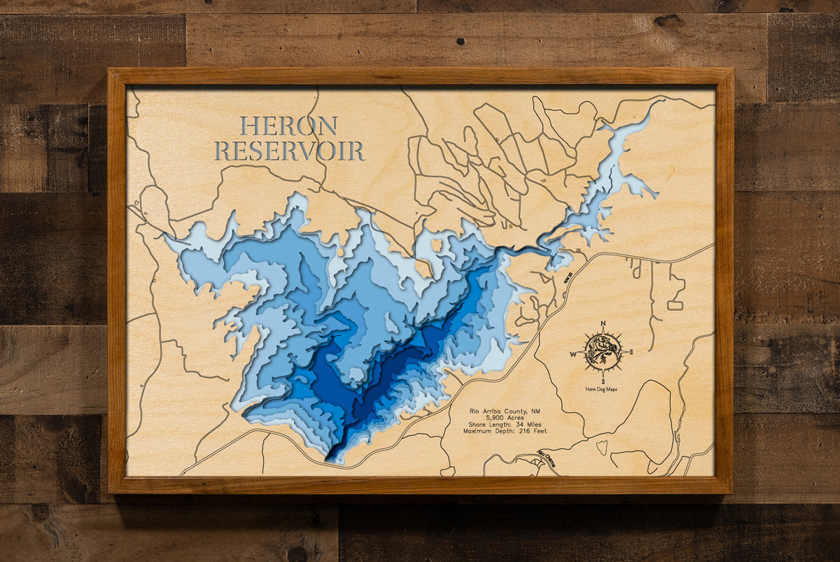 A laser-cut, layered wooden map of Heron Reservoir in Rio Arriba County, New Mexico. The distinct shape of this pristine lake, with its 11-mile shoreline, is clearly visible within the northern New Mexico landscape. The varying depths of the lake, reaching a maximum of 191 feet, are represented by different layers of wood, illustrating its impressive underwater topography.