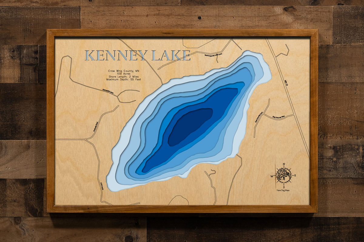 A precision laser-cut, multi-layered wooden map of Kenney Lake in Crow Wing County, Minnesota, near Garrison on the western edge of the Mille Lacs area. The natural wood top layer captures 2 miles of shoreline in fine detail, while a light-to-dark blue gradient conveys the lake's impressive 55-foot depth. A handcrafted statement piece for any Minnesota lake cabin, home, or outdoor enthusiast's wall.