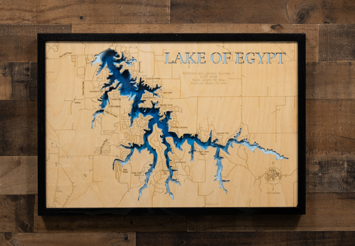A laser-cut, layered wooden map of Lake of Egypt in Williamson and Johnson counties, Illinois. The distinct shape of this large reservoir, with its 93-mile shoreline, is clearly visible within the forested landscape of southern Illinois. The varying depths of the lake, reaching a maximum of 52 feet, are represented by different layers of wood, illustrating its impressive underwater topography.