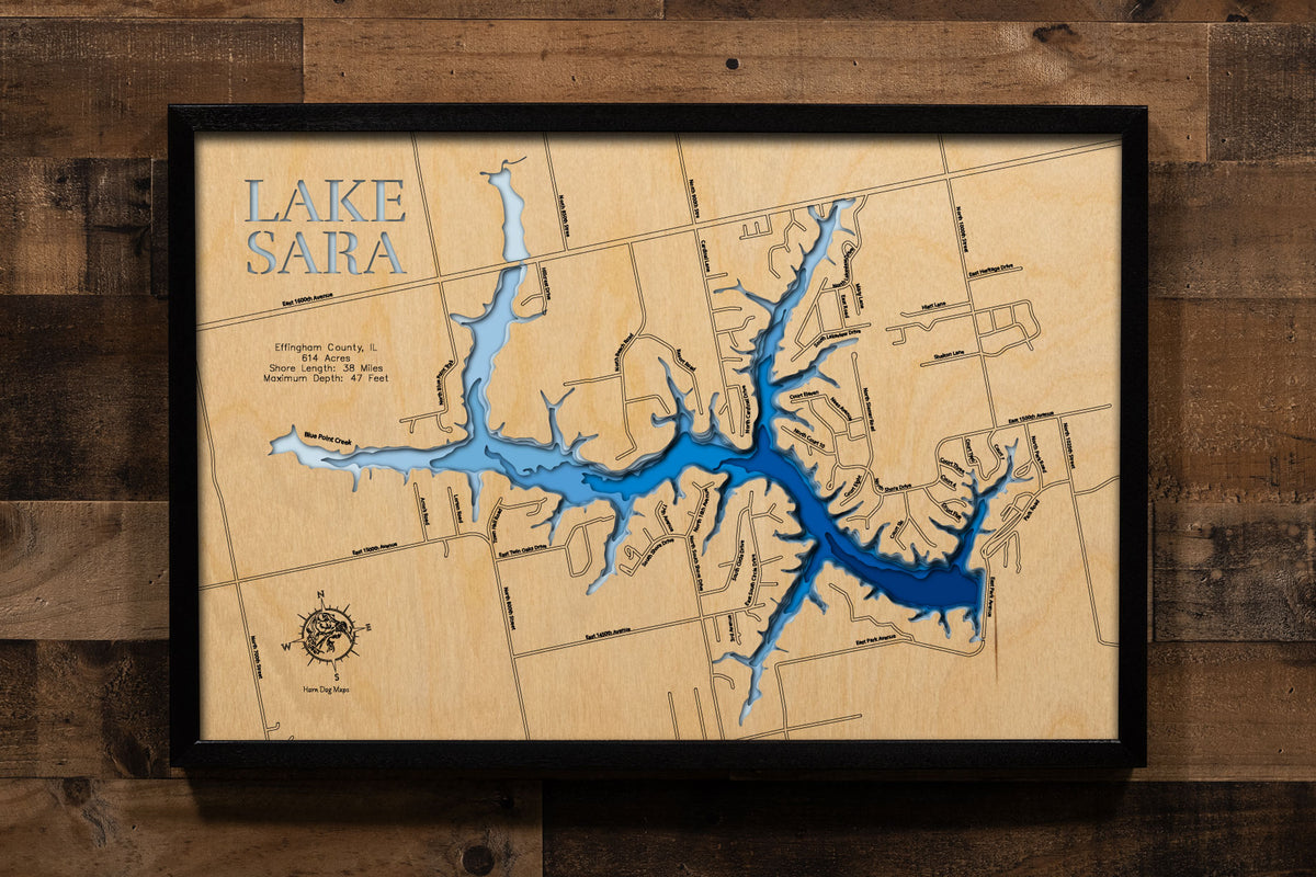 A precision laser-cut, multi-layered wooden map of Lake Sara in Effingham County, Illinois, a 614-acre community reservoir near Effingham with 38 miles of wooded shoreline and a maximum depth of 47 feet. The natural wood top layer captures every winding cove in fine detail, while a light-to-dark blue gradient conveys the lake's depth and wooded character. A handcrafted statement piece for any Illinois lake home, cabin, or outdoor enthusiast's wall.