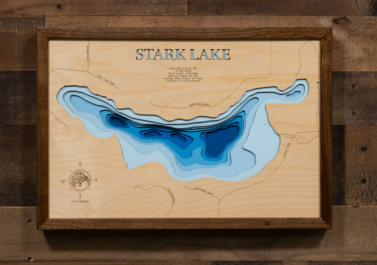 A laser-cut, layered wooden map of Stark Lake in Crow Wing County, Minnesota. The distinct shape of this natural lake, with its 3.63-mile shoreline, is clearly visible within the forested landscape of central Minnesota. The varying depths of the lake, reaching a maximum of 66 feet, are represented by different layers of wood, illustrating its impressive underwater topography.