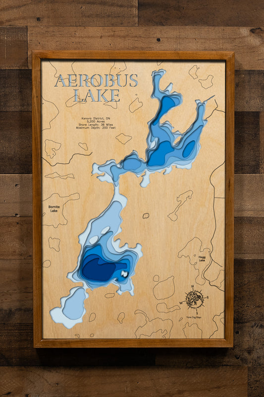 A stunning, laser-cut, multi-layered wooden topographical map of Aerobus Lake in Kenora District, Ontario, Canada, showcasing the lake's expansive 5,200-acre surface with detailed depth contours from shallow northern bays to the impressive 200-foot maximum depth in southern regions. The natural wood top layer frames 36 miles of intricate shoreline, while graduated blue layers create a captivating visual depth gradient.