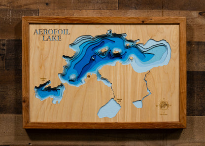 A precision laser-cut, multi-layered wooden map of Aerofoil Lake in Kenora District, Ontario — a 1,869-acre Canadian Shield wilderness lake between Dryden and Sioux Lookout with nearly 17 miles of granite-rimmed shoreline. The natural wood top layer captures every rugged cove in fine detail, while a light-to-dark blue gradient conveys the lake's 20-foot depth. A handcrafted statement piece for any Ontario fishing camp, wilderness cabin, or Canadian Shield enthusiast's wall.