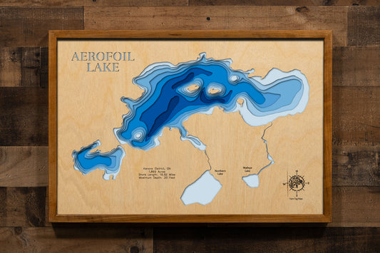A precision laser-cut, multi-layered wooden map of Aerofoil Lake in Kenora District, Ontario — a 1,869-acre Canadian Shield wilderness lake between Dryden and Sioux Lookout with nearly 17 miles of granite-rimmed shoreline. The natural wood top layer captures every rugged cove in fine detail, while a light-to-dark blue gradient conveys the lake's 20-foot depth. A handcrafted statement piece for any Ontario fishing camp, wilderness cabin, or Canadian Shield enthusiast's wall.
