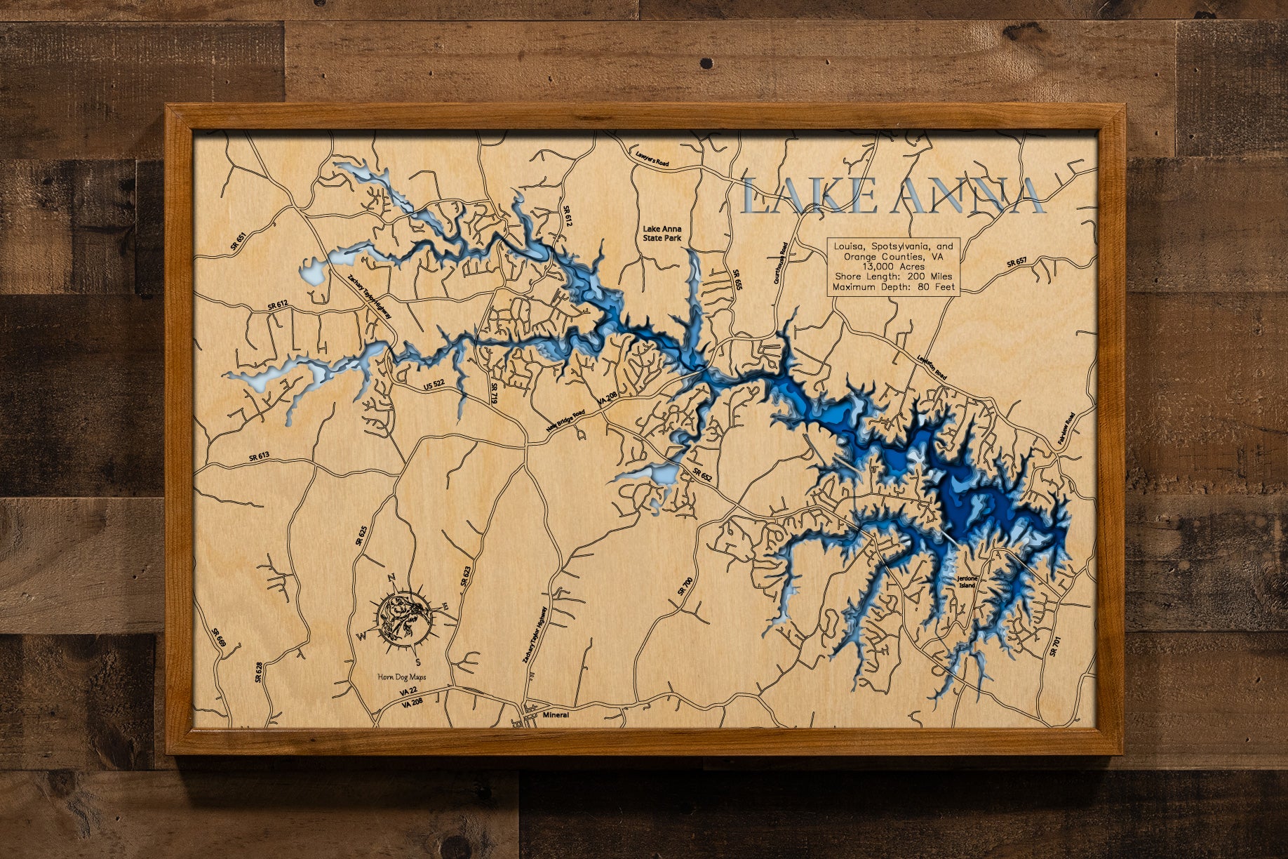 A magnificently detailed, laser-cut, multi-layered wooden topographical map of Lake Anna in Louisa, Spotsylvania, and Orange Counties, Virginia, showcasing the expansive 13,000-acre reservoir stretching 17 miles with an intricate 200 miles of shoreline. The natural wood top layer frames the three stone dikes dividing the public and private sides, the North Anna Dam, and countless coves and bays, while graduated blue layers create a stunning visual gradient from the 12-15-foot average depth to the 80-foot ma