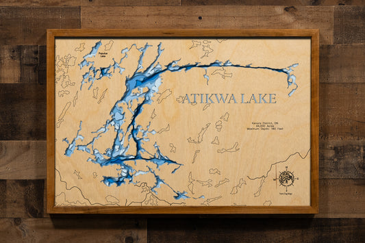 A precision laser-cut, multi-layered wooden map of Atikwa Lake in Kenora District, Ontario — a remote 44,000-acre fly-in wilderness lake renowned for trophy Lake Trout and Northern Pike. The natural wood top layer captures the vast, island-dotted shoreline of this legendary Canadian Shield lake in striking detail, while a light-to-dark blue gradient conveys its deep, crystal-clear character. A handcrafted statement piece for any Ontario fishing camp, Northwoods cabin, or wilderness angler's wall.
