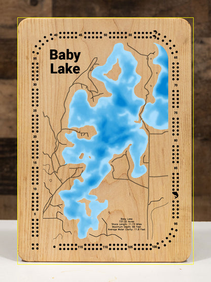 A precision laser-cut, multi-layered wooden map of Baby Lake in Cass County, Minnesota, a 737-acre Northwoods lake near Leech Lake with 12 miles of shoreline and a notable 69-foot maximum depth. The natural wood top layer captures every curve of this deceptively deep lake in fine detail, while a light-to-dark blue gradient conveys its impressive depth. A handcrafted statement piece for any Minnesota lake cabin, home, or outdoor enthusiast's wall.