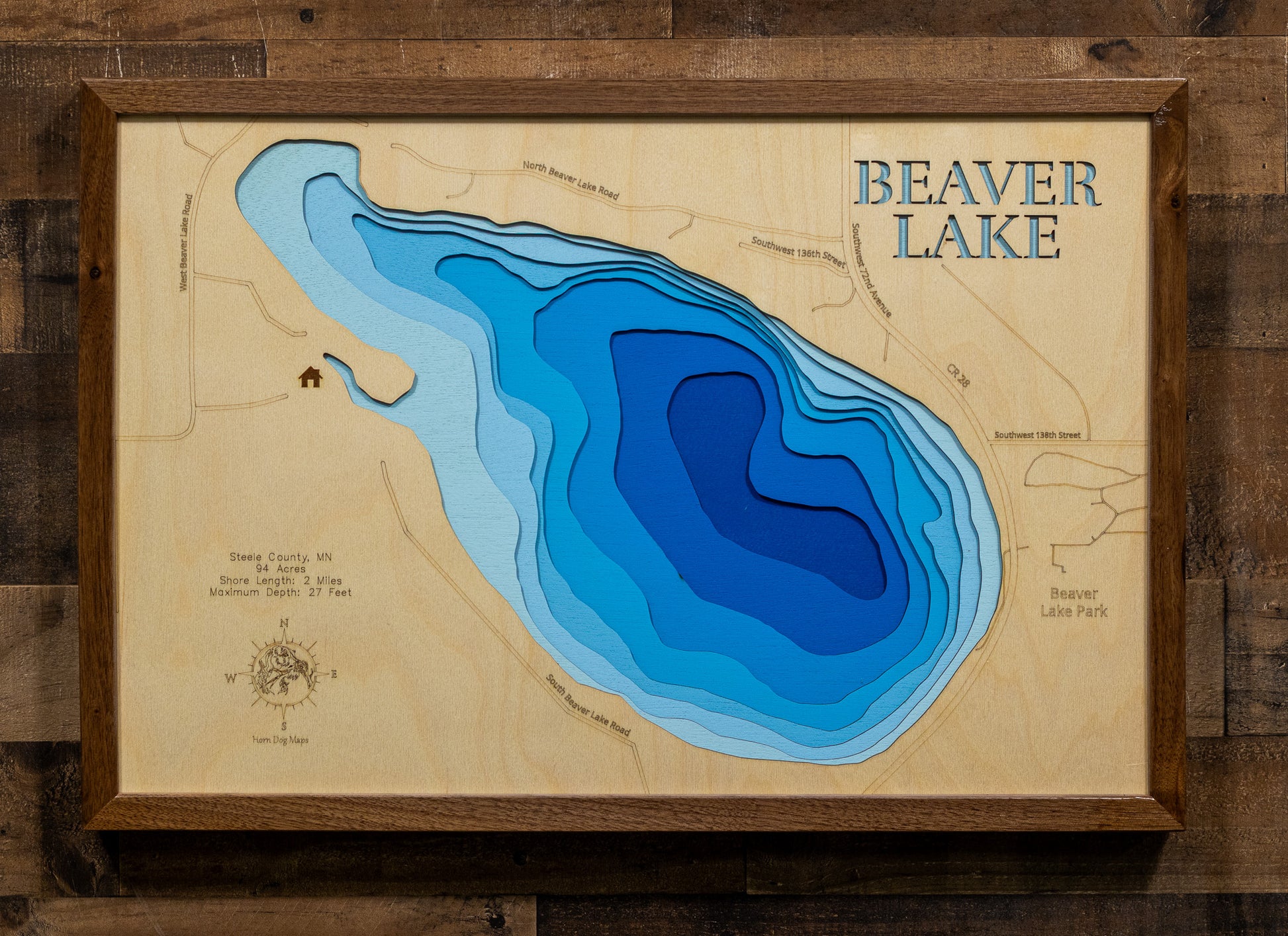 A precision laser-cut, multi-layered wooden map of Beaver Lake in Steele County, Minnesota. The natural wood top layer renders the shoreline of this spring-fed lake in fine detail, while a light-to-dark blue gradient conveys the lake's clear, calm depth of 27 feet. A handcrafted statement piece for any Minnesota lake cabin, great room, or outdoor enthusiast's wall.