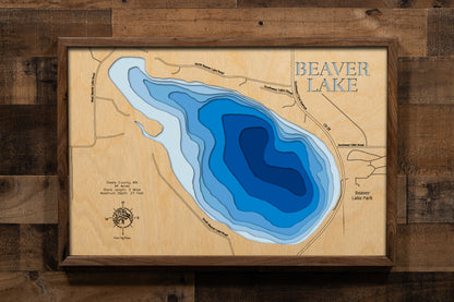 A precision laser-cut, multi-layered wooden map of Beaver Lake in Steele County, Minnesota. The natural wood top layer renders the shoreline of this spring-fed lake in fine detail, while a light-to-dark blue gradient conveys the lake's clear, calm depth of 27 feet. A handcrafted statement piece for any Minnesota lake cabin, great room, or outdoor enthusiast's wall.