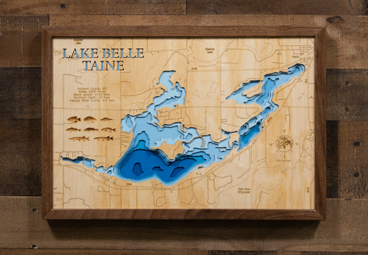 A highly detailed, 3D laser-cut wooden map of Lake Belle Taine in Hubbard County, Minnesota. The multi-layered design uses different wood tones to illustrate the lake's bathymetric contours and deepest points. Etched details include the lake name, county lines, shoreline roads, and the surrounding towns like Nevis, creating a unique and intricate piece of art.