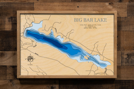 A laser-cut, layered wooden map of Big Bar Lake in the Cariboo Region, British Columbia, Canada. The distinct shape of this natural lake, with its 3-mile shoreline, is clearly visible within the forested landscape of interior British Columbia. The varying depths of the lake, reaching a maximum of 115 feet, are represented by different layers of wood, illustrating its impressive underwater topography.