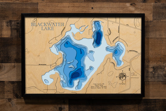 A meticulously crafted laser-cut wooden lake map of Blackwater Lake in Cass County, Minnesota. The map features the lake’s intricate shape and 7.63-mile shoreline, with its impressive 67-foot depth represented by a deep blue stain. Meticulously etched details include the lake name, county, and state, alongside key statistics like surface area and maximum depth, creating a stunning piece of bathymetric art that captures the unique geography of this beloved lake.