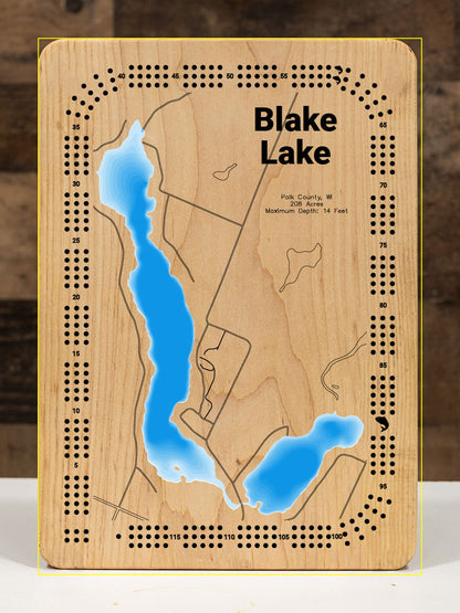 A precision laser-cut, multi-layered wooden map of Big Blake and Little Blake Lakes in Polk County, Wisconsin — a connected pair of Straight River drainage lakes covering 286 combined acres near Balsam Lake and Luck. The natural wood top layer captures both shorelines in fine detail, while a light-to-dark blue gradient conveys their warm, productive character. A handcrafted statement piece for any Wisconsin lake cabin, home, or outdoor enthusiast's wall.