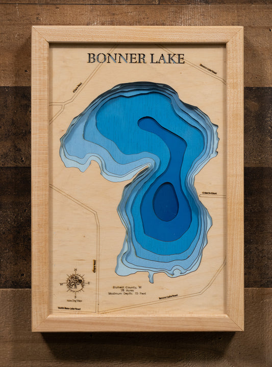 A laser-cut, layered wooden map of Bonner Lake in Burnett County, Wisconsin. The shape of the lake is visible within the northwestern Wisconsin landscape. The varying depths of the lake, reaching a maximum of 15 feet, are represented by different layers of wood.