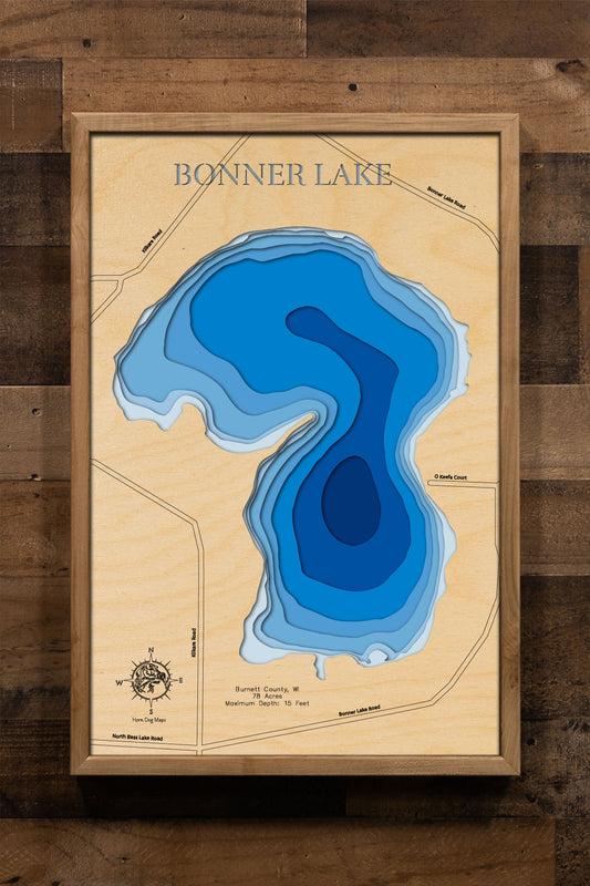 A laser-cut, layered wooden map of Bonner Lake in Burnett County, Wisconsin. The shape of the lake is visible within the northwestern Wisconsin landscape. The varying depths of the lake, reaching a maximum of 15 feet, are represented by different layers of wood.