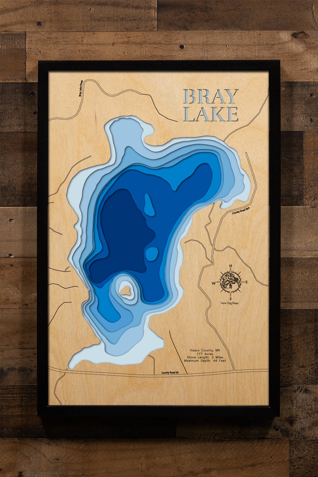 A highly detailed, laser-cut, and multi-layered wooden map of Bray Lake in Itasca County, Minnesota. The map showcases the lake's compact 177-acre surface with depth contours illustrating the descent to its impressive 44-foot maximum depth, the shallow vegetated southern bay with carry-in access, and the intimate 3 miles of forested shoreline.