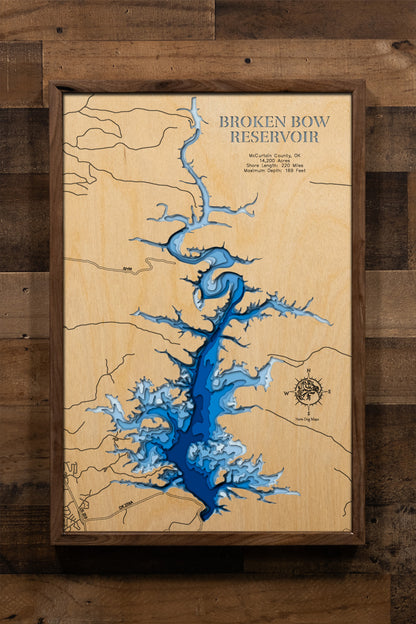 An intricately detailed, laser-cut, multi-layered wooden map of Broken Bow Lake in McCurtain County, Oklahoma. The map showcases the reservoir's 14,200-acre expanse with crystal-clear waters, depth contours revealing the dramatic 169-foot maximum depth, the 220 miles of pine-studded shoreline, scenic islands, and the Mountain Fork River.