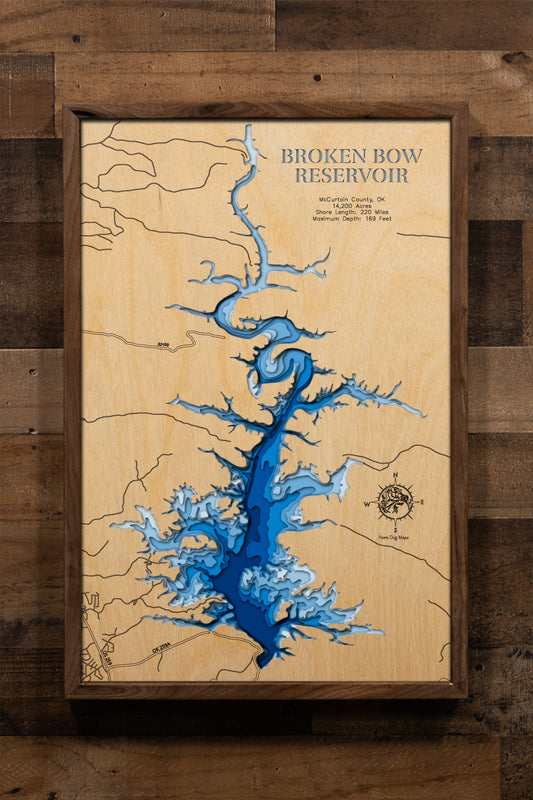 An intricately detailed, laser-cut, multi-layered wooden map of Broken Bow Lake in McCurtain County, Oklahoma. The map showcases the reservoir's 14,200-acre expanse with crystal-clear waters, depth contours revealing the dramatic 169-foot maximum depth, the 220 miles of pine-studded shoreline, scenic islands, and the Mountain Fork River.