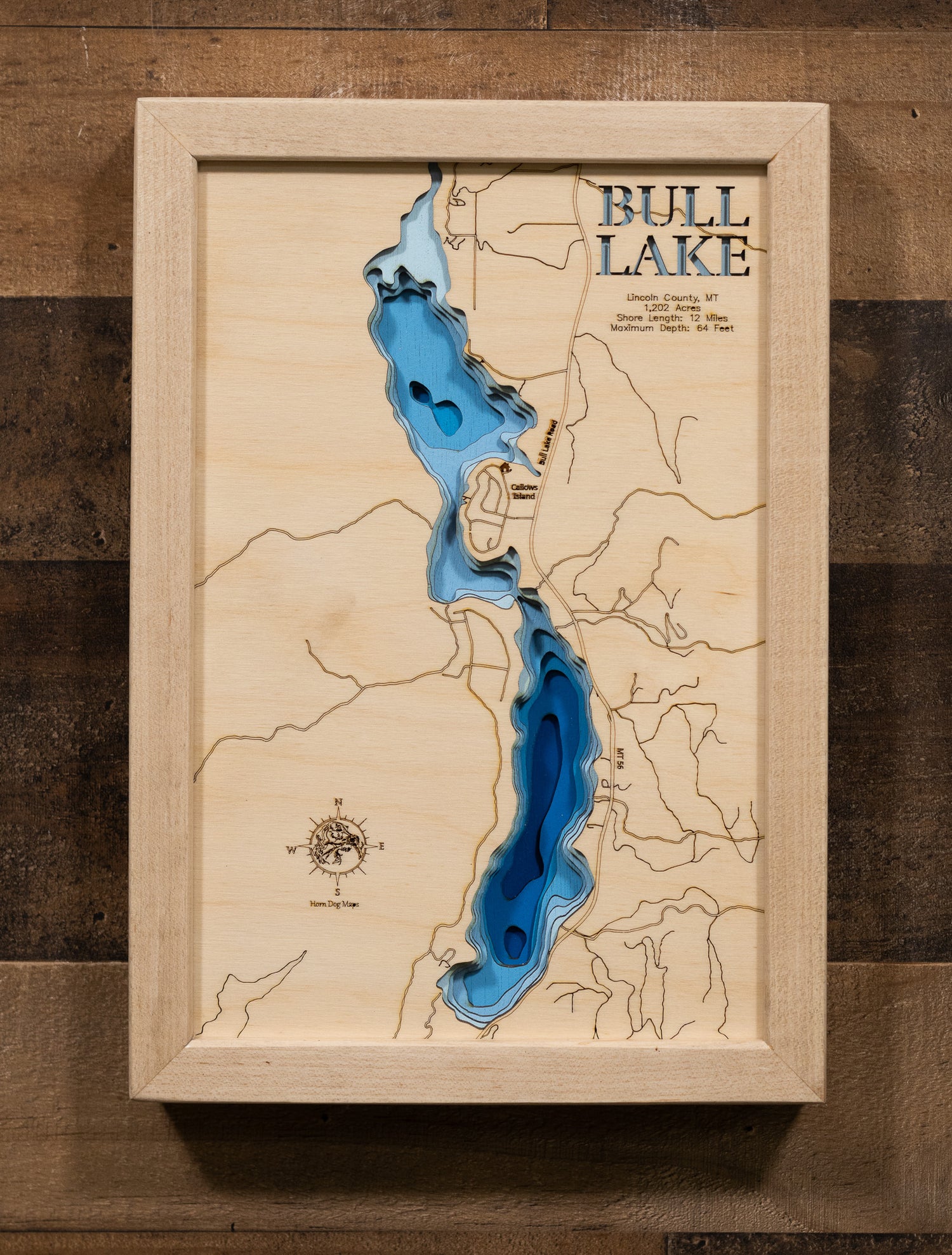 County, Montana, nestled in the Cabinet Mountains foothills, showcasing the 1,202-acre pristine mountain lake's 12 miles of forested shoreline, depth contours revealing the 64-foot maximum depth, and Montana Highway 56 running along the eastern shore.