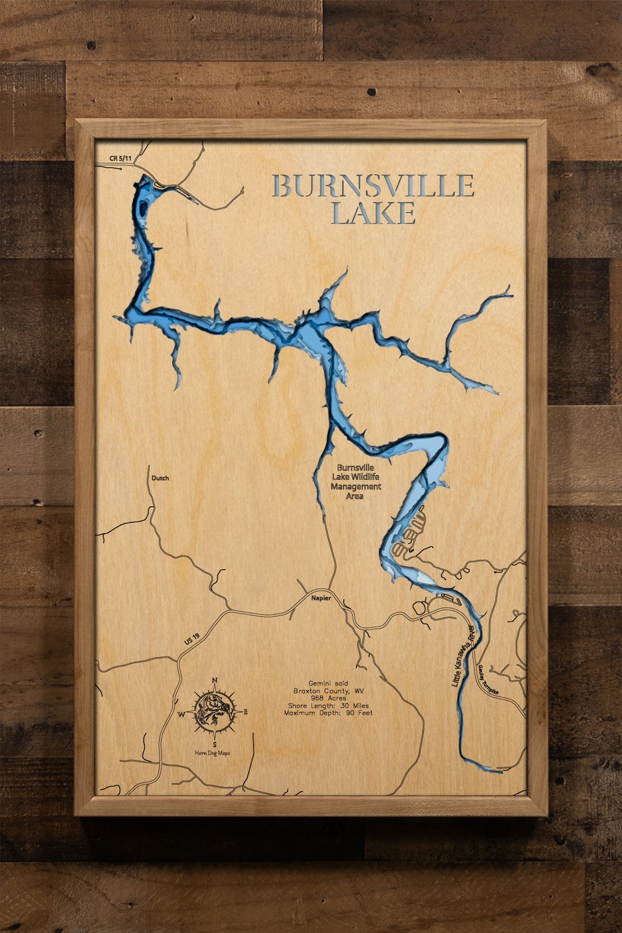 A precision laser-cut wooden map of Burnsville Lake, West Virginia, 
featuring a natural wood top layer and a multi-level blue gradient 
for the water. The 3D topographic design highlights the 30-mile 
shoreline and 90-foot depth in a sophisticated art piece. It is a 
rustic yet modern home decor item that perfectly captures the 
unique shape of this Braxton County reservoir for any cabin wall.