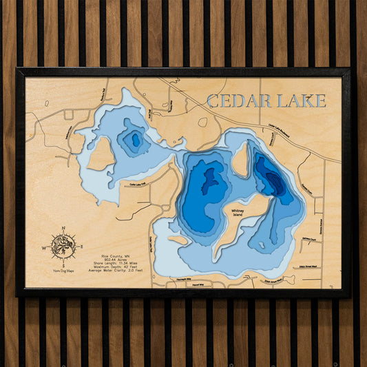A precision laser-cut, multi-layered wooden map of Cedar Lake in Rice County, Minnesota. The natural wood top layer captures over 11 miles of shoreline and four distinctive islands in fine detail, while a light-to-dark blue gradient conveys the lake's 42-foot depth. A handcrafted statement piece for any southern Minnesota lake home, cabin, or fishing enthusiast's wall.