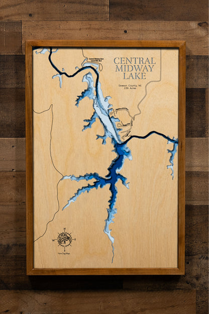 A laser-cut, layered wooden map of Central Midway Lake in Dawson County, Nebraska. The distinct shape of this reservoir, part of the Canyon Reservoirs system, is clearly visible within the prairie landscape of Nebraska. The varying depths of the lake are represented by different layers of wood, illustrating its underwater topography.