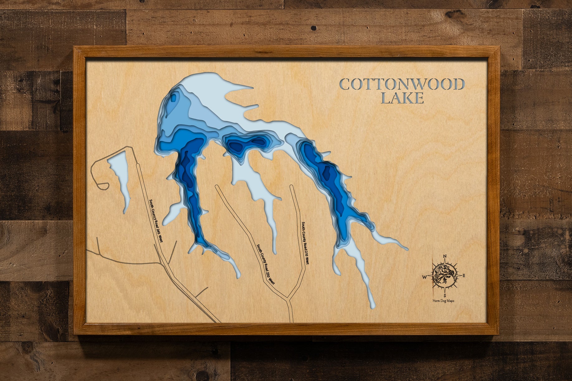 A meticulously crafted laser-cut wooden map of Cottonwood Lake in 
Greensburg, Indiana. This 3D topographic piece features a natural 
wood top layer representing the land, with recessed water layers 
stained in a light-to-dark blue gradient to reflect the lake's 
65-foot depth. It is a striking decor item that highlights the 
intricate details of the 30-acre reservoir and its 1.2-mile 
shoreline, ideal for any modern or rustic interior.