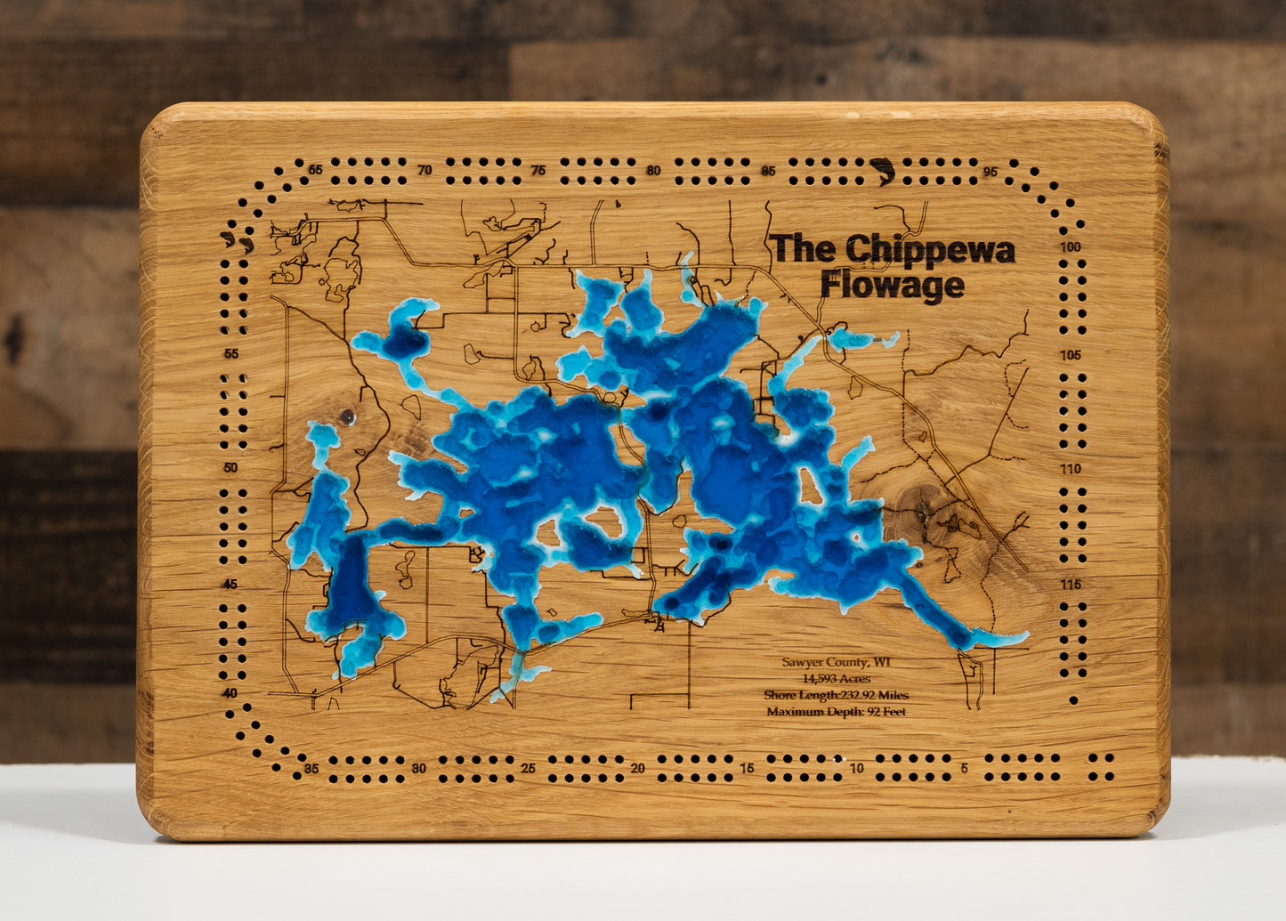 oak Cribbage board with Lake Minnetonka 3d carved into it and then filled in with blue epoxy.