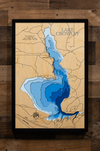 A precision laser-cut, multi-layered wooden map of Crowley Lake in Mono County, California — a legendary Eastern Sierra reservoir at 6,781 feet elevation. The natural wood top layer captures 45 miles of rugged High Desert shoreline in striking detail, while a light-to-dark blue gradient conveys the lake's 100-foot depth. A handcrafted statement piece for any California mountain cabin, fly fishing retreat, or Eastern Sierra enthusiast's wall.