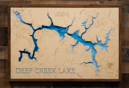 A laser-cut, layered wood map of Deep Creek Lake, Maryland, highlighting its winding shoreline, coves, and surrounding mountainous terrain in Garrett County.