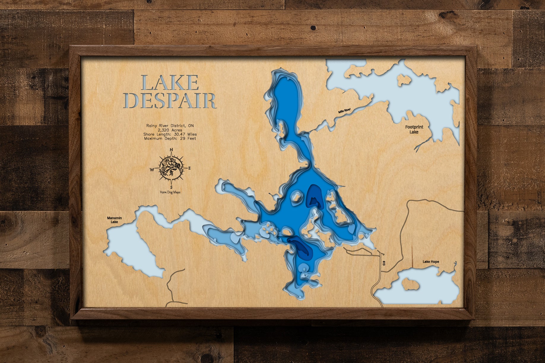 A beautifully detailed, laser-cut, multi-layered wooden map of Lake Despair in Rainy River District, Ontario, showcasing the lake's shallow contours and tea-colored waters, the intricate shoreline dotted with islands, and the connecting waterways of Mile River leading to Footprint Lake and Jackfish Narrows.