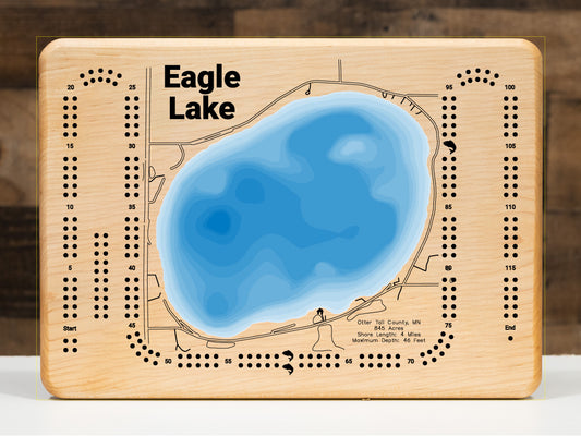 A beautifully detailed, laser-cut, multi-layered wooden topographical map of Eagle Lake in Otter Tail County, Minnesota, showcasing the 845-acre pristine closed-basin lake with exceptional clarity and depth contours from sand and gravel shallows to the 46-foot maximum depth. The natural wood top layer frames four miles of developed shoreline with the public beach and boat launch, while graduated blue layers create a striking visual depth gradient.