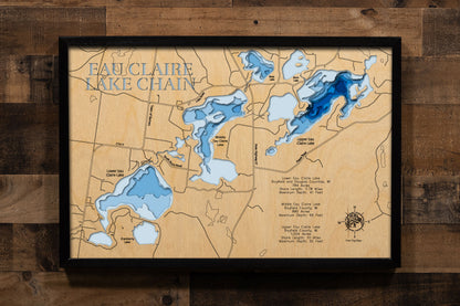 A precision laser-cut, multi-layered wooden map of the Eau Claire Lakes Chain in Bayfield County, Wisconsin, capturing Lower (784 acres), Middle (880 acres), and Upper (1,024 acres) Eau Claire Lakes connected in one of northern Wisconsin's most pristine glacial lake systems. The natural wood top layer traces all three shorelines and their connecting channels in fine detail, while a light-to-dark blue gradient conveys depths ranging from 41 to 92 feet. A handcrafted statement piece for any Wisconsin Northwoo