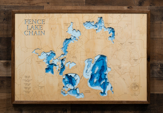 A laser-cut, layered wooden map of the Fence Chain of Lakes in Vilas County, Wisconsin. The interconnected shapes of Fence Lake, Crawling Stone Lake, Flambeau Lake, Pokegama Lake, and White Sand Lake are clearly visible within the Vilas County landscape. The varying depths of each lake are represented by different layers of wood, illustrating the underwater topography of this beautiful chain.