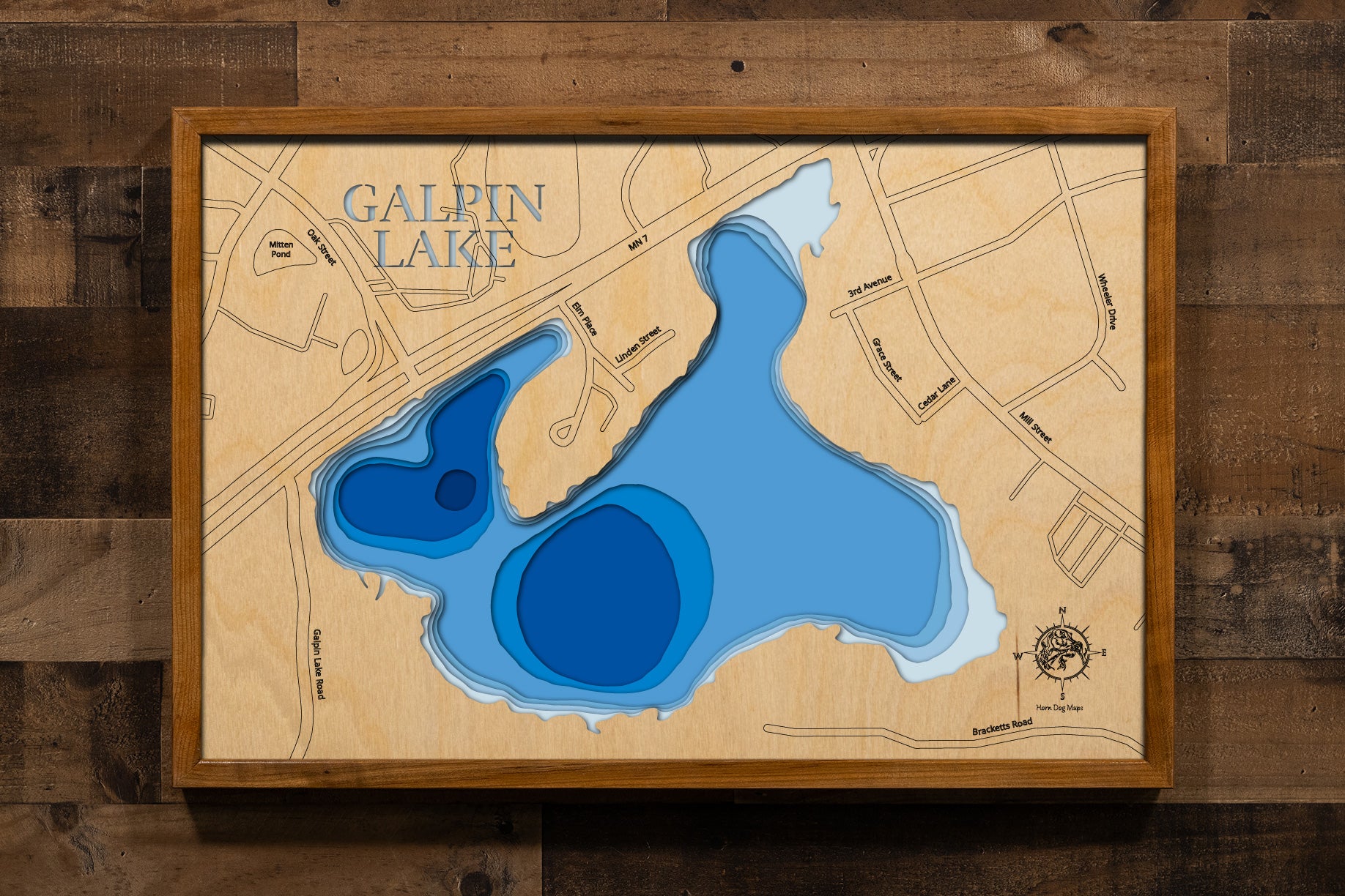 A precision laser-cut, multi-layered wooden map of Galpin Lake in Hennepin County, Minnesota, spanning the cities of Excelsior and Shorewood near Lake Minnetonka. The natural wood top layer captures the shoreline of this small, storied lake in fine detail, while a light-to-dark blue gradient brings its quiet character to life. A handcrafted statement piece for any Twin Cities lake home, cabin, or outdoor enthusiast's wall.