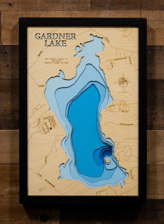 A precision laser-cut, multi-layered wooden map of Gardner Lake in New London County, Connecticut, a 529-acre natural lake spanning Salem, Montville, and Bozrah near Mystic and the Thames River valley. The natural wood top layer captures the lake's shoreline and Minnie Island in fine detail, while a light-to-dark blue gradient conveys its 39-foot depth. A handcrafted statement piece for any Connecticut lake home, cabin, or New England outdoor enthusiast's wall.