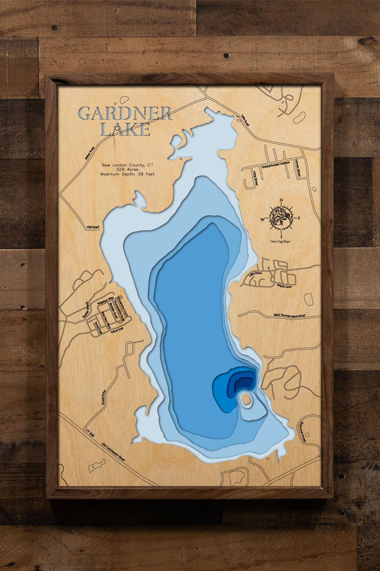 A precision laser-cut, multi-layered wooden map of Gardner Lake in New London County, Connecticut, a 529-acre natural lake spanning Salem, Montville, and Bozrah near Mystic and the Thames River valley. The natural wood top layer captures the lake's shoreline and Minnie Island in fine detail, while a light-to-dark blue gradient conveys its 39-foot depth. A handcrafted statement piece for any Connecticut lake home, cabin, or New England outdoor enthusiast's wall.