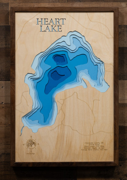 A laser-cut, layered wood map of Heart Lake, Minnesota, illustrating its winding shoreline and forested surroundings in Clearwater County.