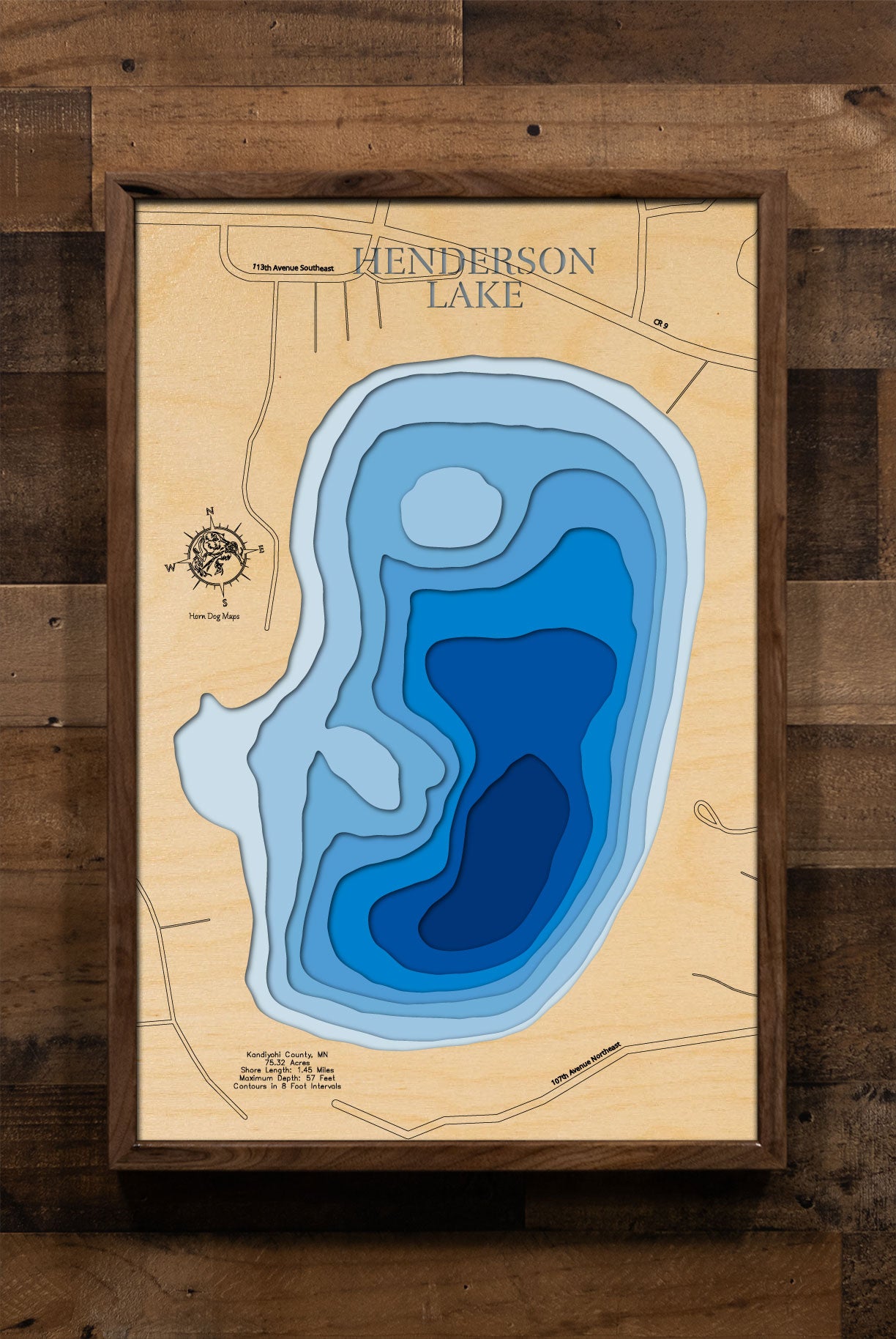 A laser-cut, layered wooden map of Henderson Lake in Kandiyohi County, Minnesota. The distinct shape of this natural lake, with its 1.45-mile shoreline, is clearly visible within the central Minnesota landscape. The varying depths of the lake, reaching a maximum of 57 feet and detailed by 8-foot contour intervals, are represented by different layers of wood, illustrating its impressive underwater topography.