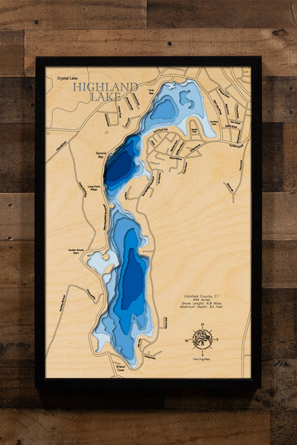 A laser-cut, layered wooden map of Highland Lake in Litchfield County, Connecticut. The distinct shape of this natural lake, with its 6.8-mile shoreline, is clearly visible within the forested landscape of Winchester. The varying depths of the lake, reaching a maximum of 110 feet, are represented by different layers of wood, illustrating its impressive underwater topography.