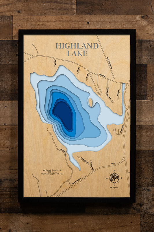 A precision laser-cut, multi-layered wooden map of Highland Lake in Merrimack County, New Hampshire — a spring-fed coldwater lake in Andover stocked annually with Brook and Rainbow Trout. The natural wood top layer captures the lake's scenic New England shoreline in fine detail, while a light-to-dark blue gradient conveys its 44-foot depth. A handcrafted statement piece for any New Hampshire lake cottage, Lakes Region home, or outdoor enthusiast's wall.