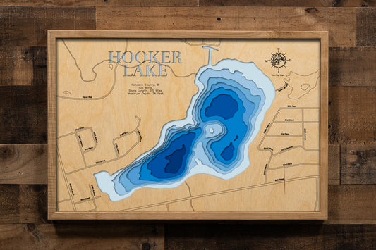 A highly detailed, laser-cut, and multi-layered wooden map of Hooker Lake in Kenosha County, Wisconsin. The map showcases the lake's compact 103-acre surface with depth contours illustrating the shallow 14-foot northern weedy flats contrasting with the deeper southern basin reaching 24 feet, and the intimate shoreline of this Village of Paddock Lake gem.