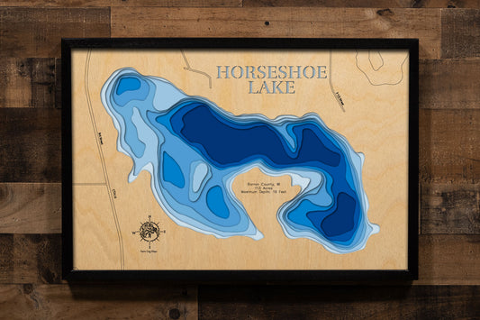 A precision laser-cut, multi-layered wooden map of Horseshoe Lake in Barron County, Wisconsin, just north of Cumberland. The natural wood top layer captures the lake's distinctive horseshoe-shaped shoreline in fine detail, while a light-to-dark blue gradient conveys its 19-foot depth. A handcrafted statement piece for any Wisconsin lake cabin, home, or outdoor enthusiast's wall.