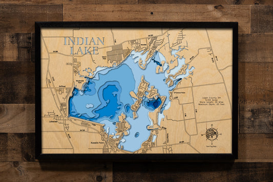 A highly detailed, laser-cut, and multi-layered wooden map of Indian Lake in Logan County, Ohio. The map showcases the reservoir's distinctive 5,104-acre shape with the iconic Indian Isles island chain arcing through its center, depth contours illustrating the shallow 20-foot maximum depth, and the intricate 30 miles of shoreline with numerous bays and inlets.
