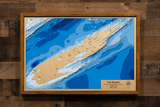 A laser-cut, layered wooden map showcasing Isle Royale, detailed with its intricate network of inland lakes, rugged topography, and surrounding smaller islands, all set within the vast expanse of Lake Superior. The map highlights the island's elongated shape and its remote location, emphasizing its wilderness character as a national park.