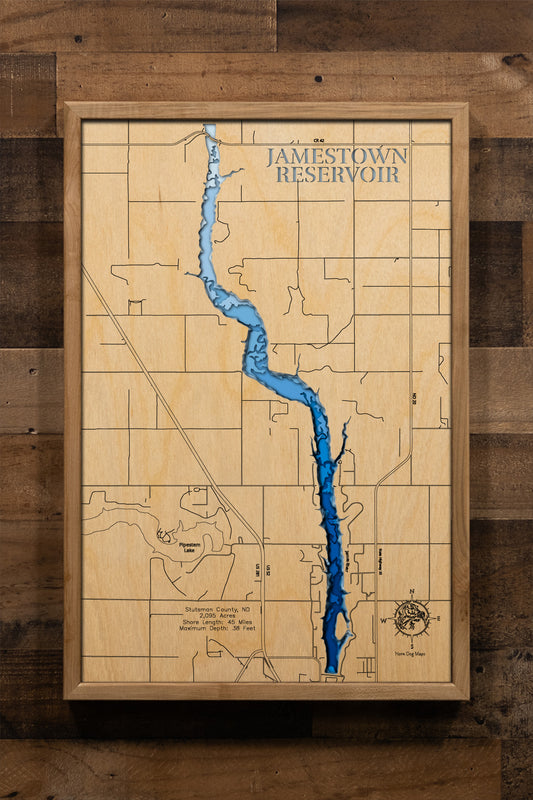 A highly detailed, laser-cut, and multi-layered wooden map of Jamestown Reservoir in Stutsman County, North Dakota. The map highlights the 2,095-acre reservoir's winding 8-mile length along the James River valley, with depth contours showing the 38-foot maximum depth, the unique peninsula and island features, and the intricate 45 miles of shoreline.