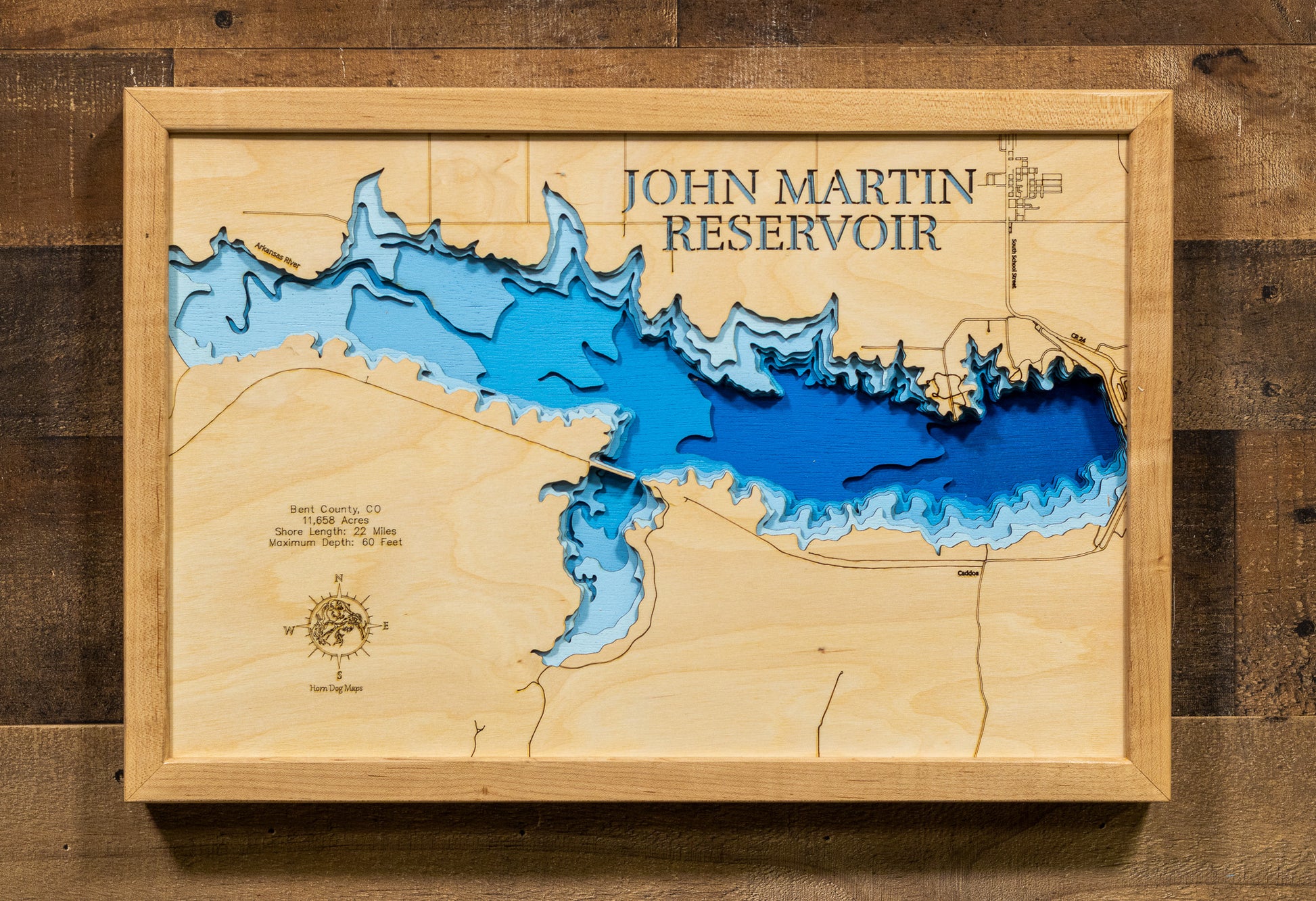 A laser-cut, layered wood map of John Martin Reservoir, Colorado, showcasing its vast shoreline and surrounding prairie landscape.