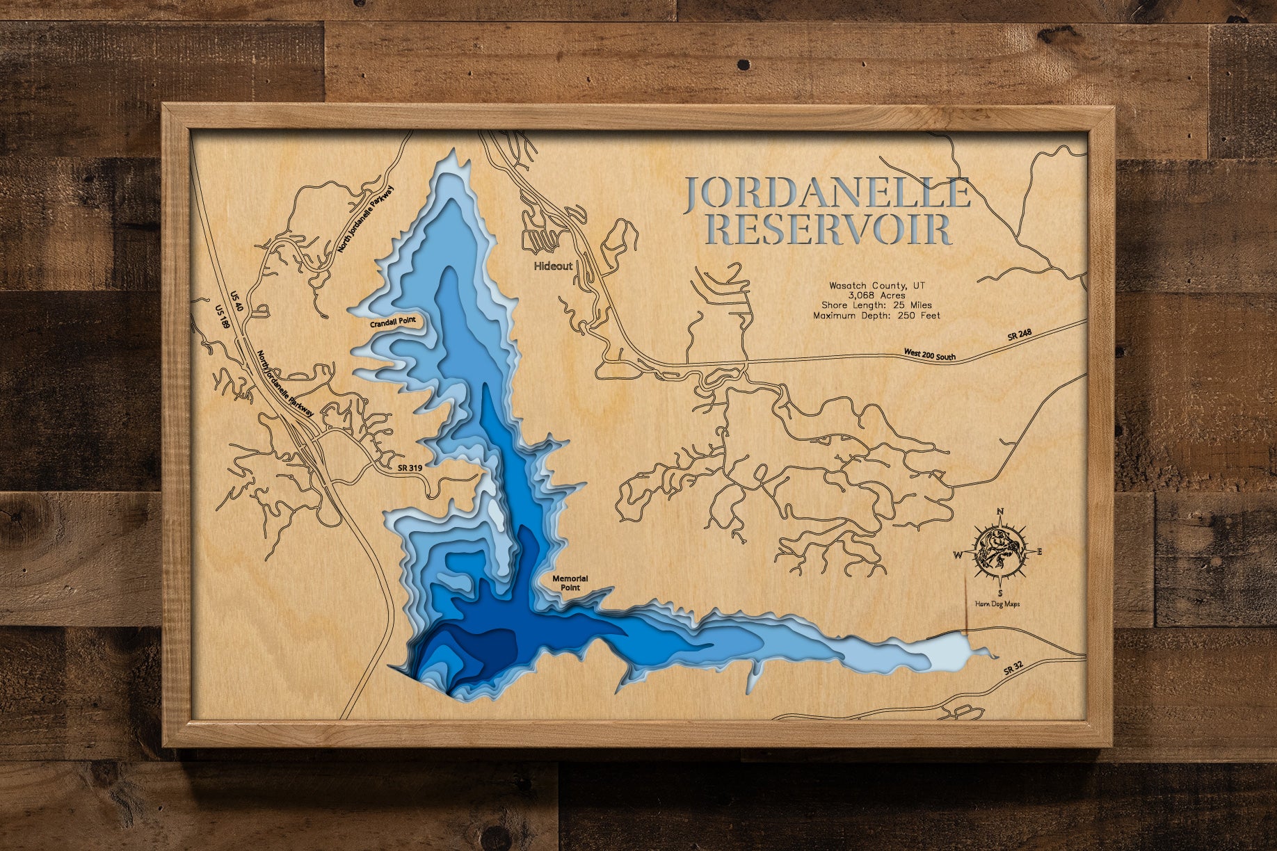 A precision laser-cut, multi-layered wooden map of Jordanelle Reservoir in Wasatch County, Utah — a high-elevation Provo River reservoir between Park City and Heber City. The natural wood top layer captures 25 miles of mountain shoreline in fine detail, while a light-to-dark blue gradient conveys the reservoir's striking 250-foot depth. A handcrafted statement piece for any Utah mountain cabin, Wasatch Range home, or outdoor enthusiast's wall.