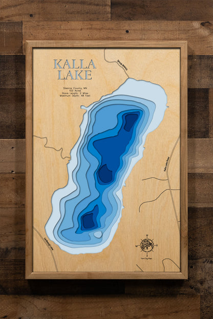 A precision laser-cut, multi-layered wooden map of Kalla Lake in Stearns County, Minnesota, a private 103-acre lake in the Avon Hills near Avon with no public access and only seven shoreline homes. The natural wood top layer captures 2 miles of forested shoreline in fine detail, while a light-to-dark blue gradient conveys the lake's 48-foot depth. A handcrafted statement piece for any Minnesota lake home, cabin, or outdoor enthusiast's wall.